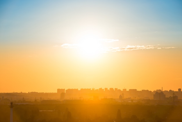 Tramonto della città con silhouette di edifici sullo skyline arancione