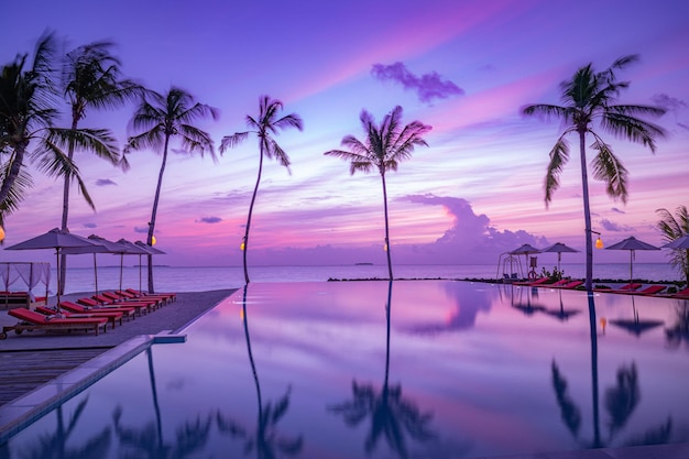 Tramonto di lusso sulla piscina a sfioro in un resort estivo sulla spiaggia in uno splendido paesaggio tropicale