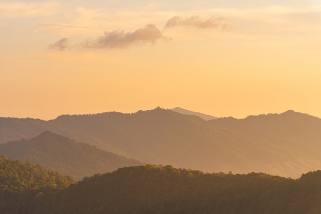 Tramonto di punto di vista dell'angolo alto sopra le montagne e la foresta