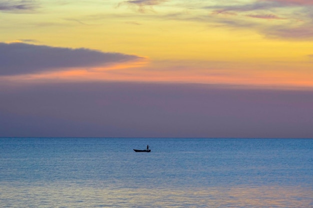 Tramonto di sera e pescatore pesca da lontano in Tanjung Aru Kota Kinabalu beach nel Borneo Sabah Malaysia