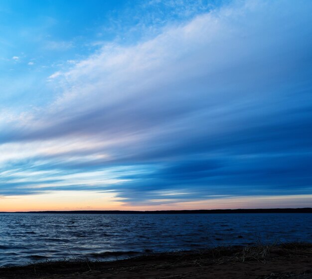 Tramonto drammatico quadrato sullo sfondo a lunga esposizione dell'orizzonte del lago