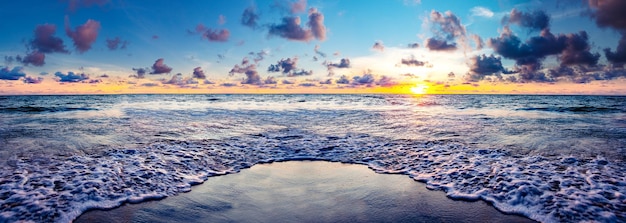 Tramonto fantasia e panorama della spiaggia Tramonto da sogno a riva della spiaggia