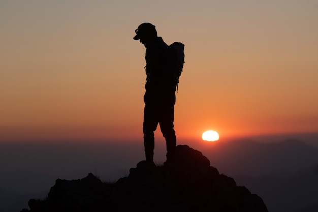 Tramonto idilliaco con un alpinista iin silhuettes n summit