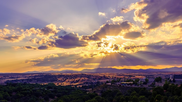 Tramonto in montagna con belle nuvole e raggi di sole in tutte le direzioni. Madrid, Spagna.