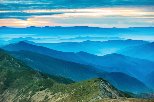 Tramonto in montagna. Drammatico cielo colorato con colline blu