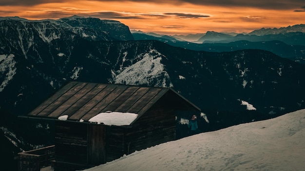 Tramonto in montagna in inverno e una piccola baita