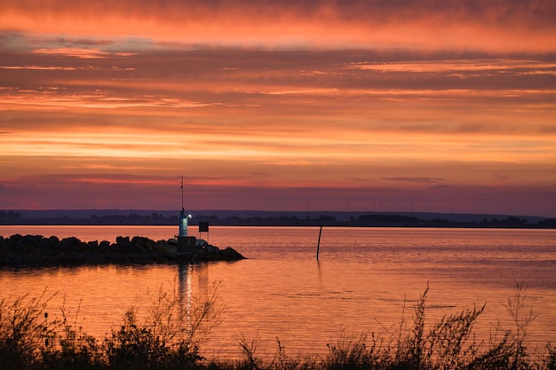 Tramonto in Svezia al porto del lago Vaetten Faro sullo sfondo