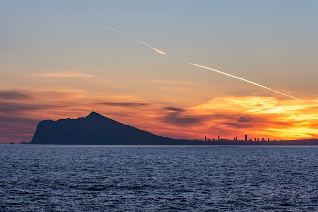 Tramonto nella città di Benidorm, con un mare bluastro.