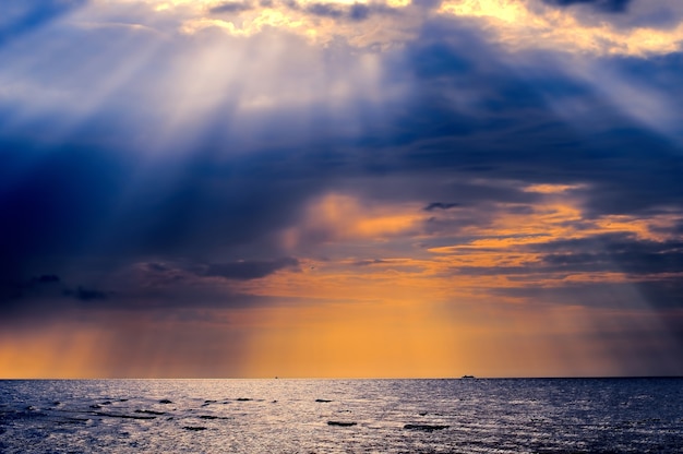 Tramonto nuvoloso sul Mar Baltico. Sembrano raggi dal cielo.