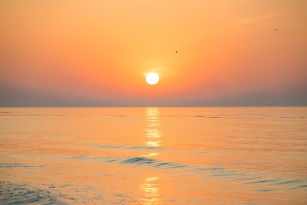 Tramonto o alba sul mare con il sole sul bellissimo cielo drammatico