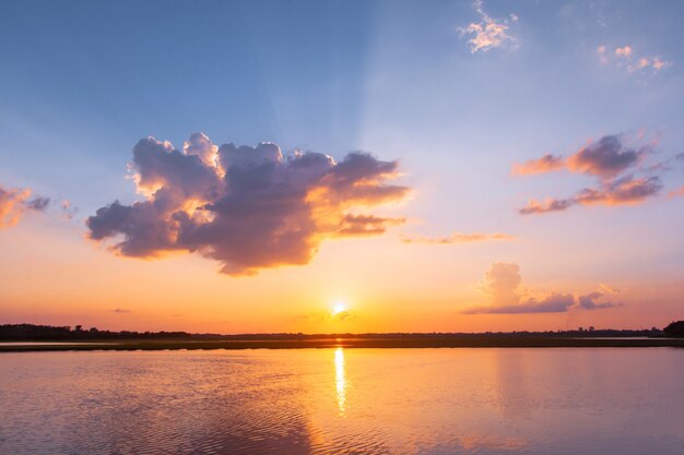 Tramonto riflesso laguna. bel tramonto dietro le nuvole e il cielo blu sopra il paesaggio lagunare