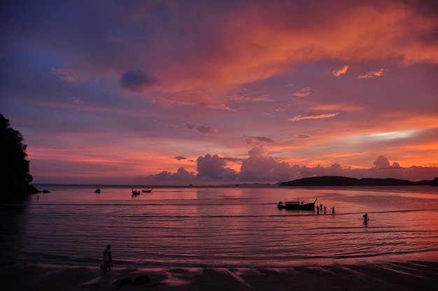 Tramonto rosa sul litorale, spiaggia di Ao Nang con onde calme contro il cielo tropicale multicolore, Thailandia.