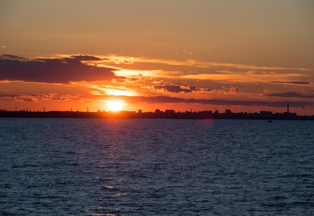 tramonto rosso fuoco sulla città Tramonto tra nuvola e città