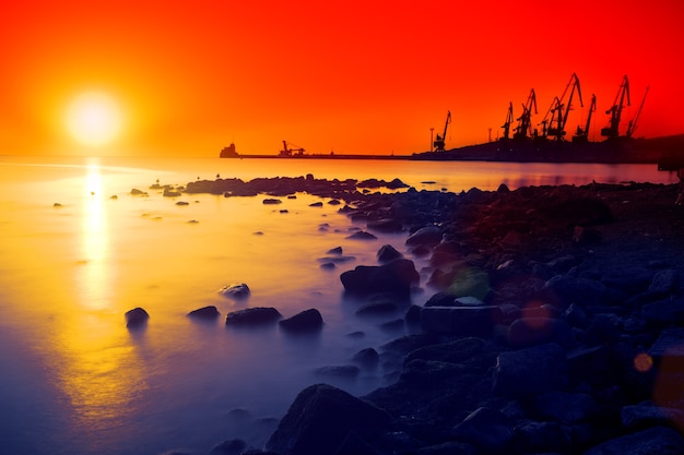 Tramonto rosso sulla spiaggia di pietra