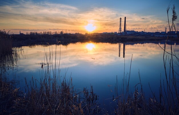 Tramonto serale sul fiume con tempo calmo sullo sfondo della città.