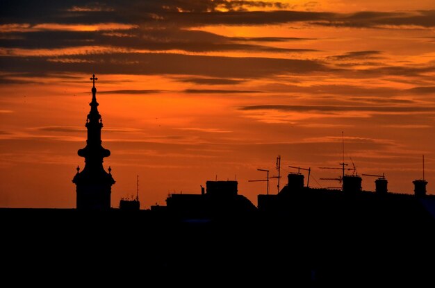 Tramonto silhouette skyline Novi Sad Serbia edifici con antenne e chiesa