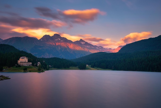 Tramonto sopra il lago st moritzersee con le alpi svizzere e un hotel di montagna