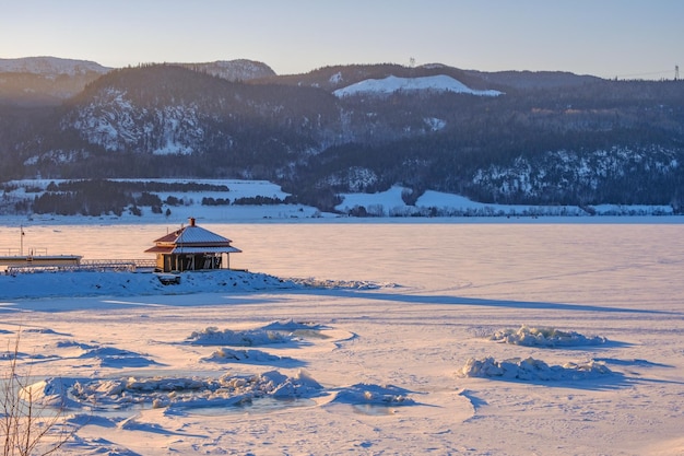 Tramonto sul fiordo di Saguenay ghiacciato e innevato nel villaggio di Anse Saint Jean, in Quebec, Canada