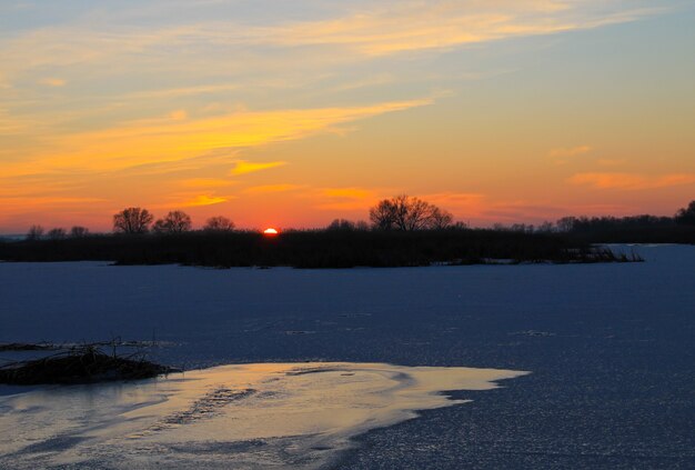 Tramonto sul fiume ghiacciato Dnieper in inverno