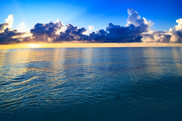 Tramonto sul mare con cielo nuvoloso e sole attraverso le nuvole sopra Nuvole Vista sul mare sullo sfondo del cielo e dell'oceano