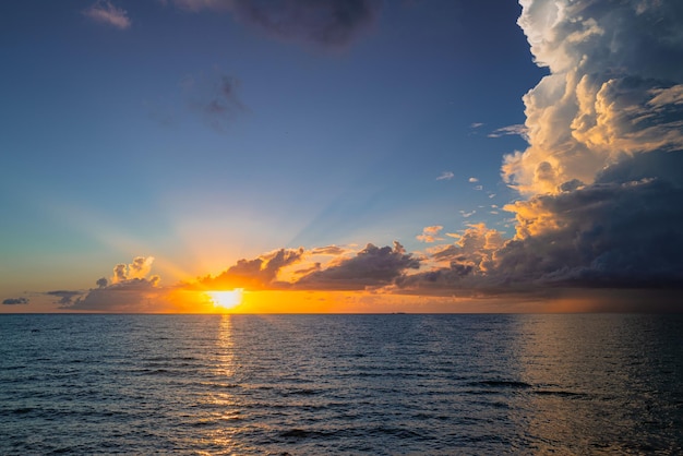 Tramonto sull'alba della spiaggia dell'oceano mare con cielo nuvoloso calmo