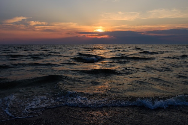 Tramonto sull'orizzonte di sera della spiaggia del mare