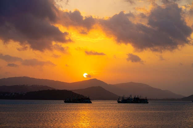 Tramonto sulla baia con barche da pesca