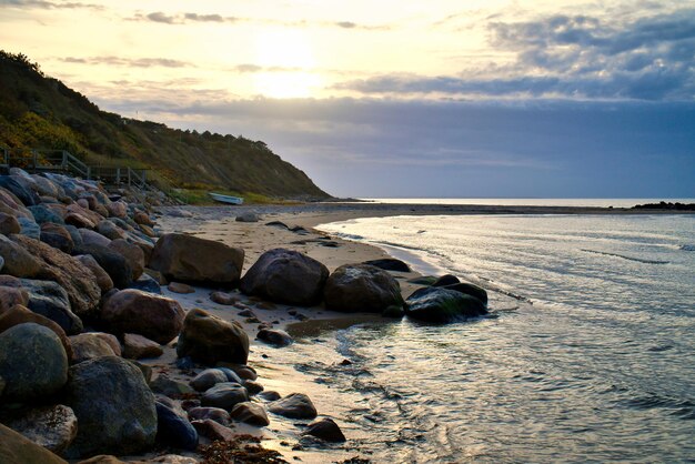 Tramonto sulla costa danese Beach onde Collina con alberi sullo sfondo Paesaggio