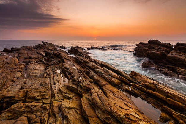 Tramonto sulla costa rocciosa di un'isola tropicale