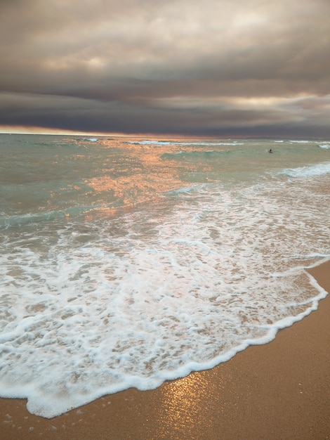 Tramonto sulla spiaggia con nuvole scure su vilamoura, Portogallo.