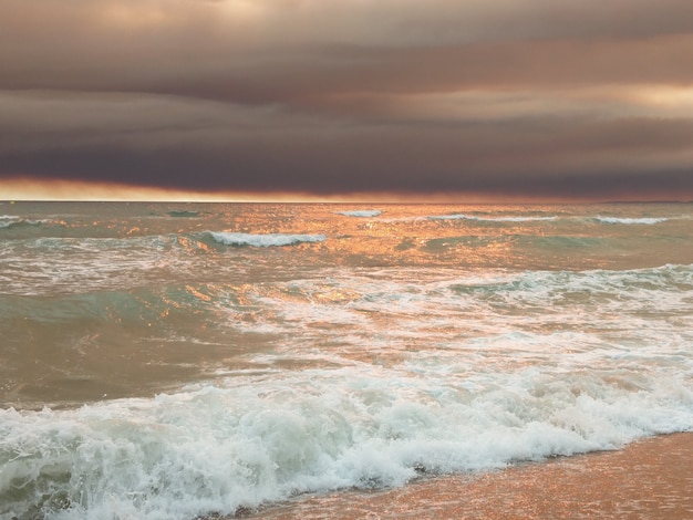 Tramonto sulla spiaggia con nuvole scure su vilamoura, Portogallo.