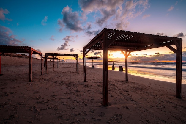 Tramonto sulla spiaggia con ombrelloni Serata sulla spiaggia deserta Cesarea Israele