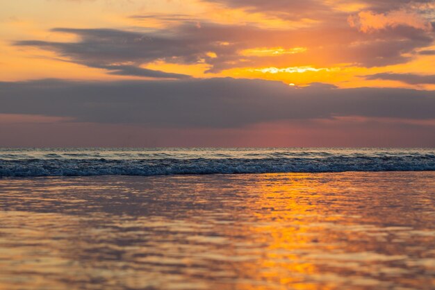 Tramonto sulla spiaggia di Kuta con riflesso nell'acqua sull'isola di Bali