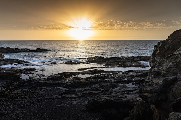 tramonto sulla spiaggia vulcanica e rocciosa di Fuerteventura