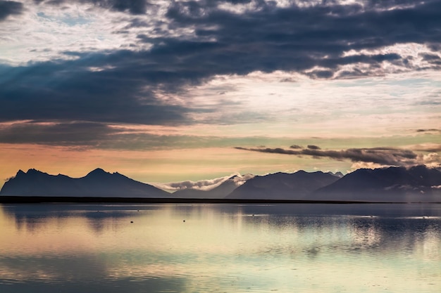 Tramonto sulle montagne in riva al mare come sfondo