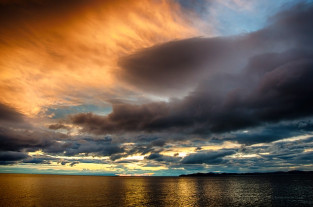 Tramonto tra le nuvole tempestose sopra l'acqua