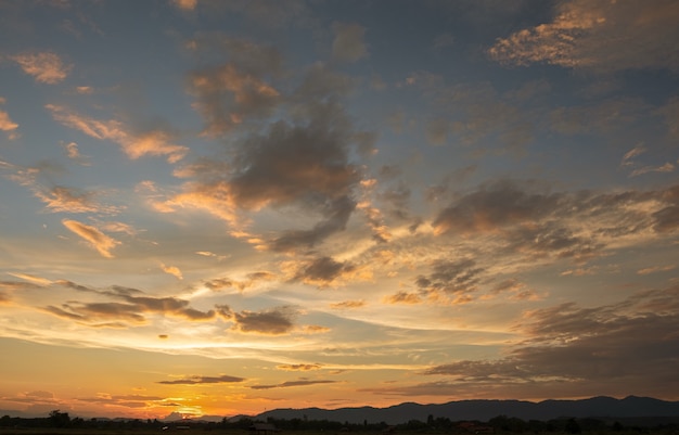 Tramonto variopinto e alba con nuvole. Colore arancione della natura. Molte nuvole bianche nel cielo. Il tempo è sereno oggi. Tramonto tra le nuvole. Il cielo è crepuscolare.