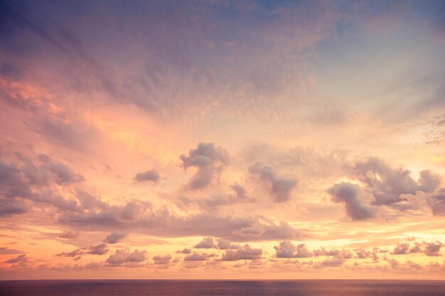 Tramonto viola con oceano calmo e nuvole