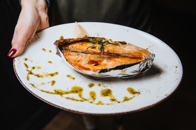 Trancio di pesce al forno succoso su un piatto rotondo