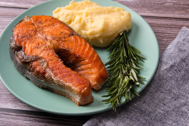 trancio di salmone alla griglia con purè di patate su un piatto. pesce rosso