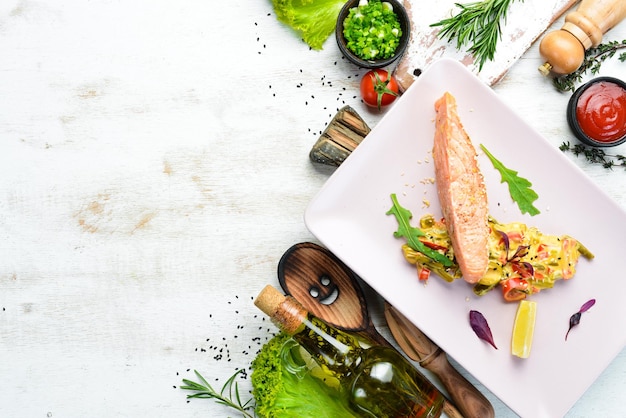 Trancio di salmone con insalata e salsa. Vista dall'alto. Spazio libero per il tuo testo.