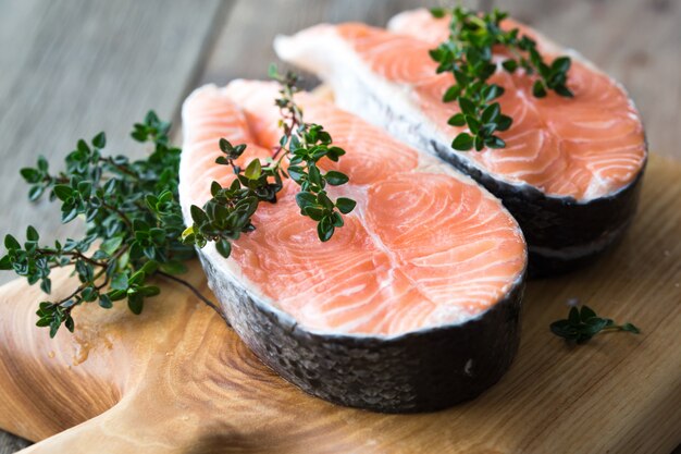 Trancio di salmone crudo e fresco su una tavola e spezie intorno. Pesce rosso salmone crudo. Cucinare salmone, frutti di mare. Concetto di cibo sano. Salmone e spezie