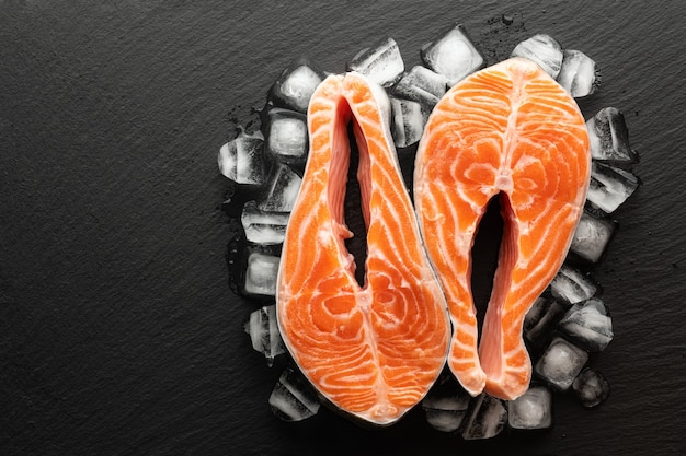 Trancio di salmone refrigerato e ghiaccio su uno sfondo di pietra, vista dall'alto, posto per il testo