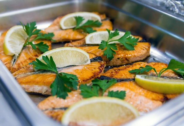 Trancio di salmone rosa arrosto con foglie di prezzemolo e limone