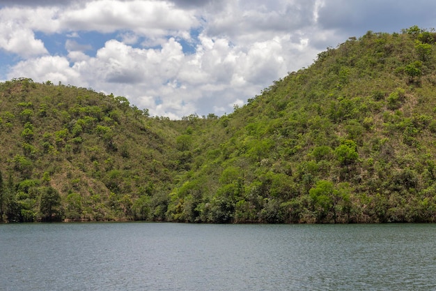 Tranquillo lago di acque verdi con montagne e cielo blu con molte nuvole sullo sfondo