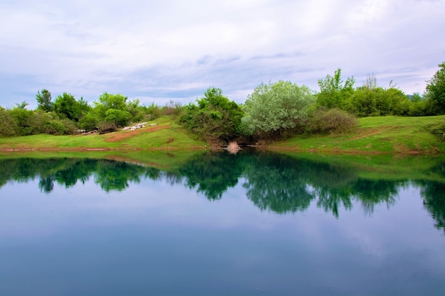 Tranquillo paesaggio sul lago con un bellissimo riflesso sulle acque calme Shegans Eye Albania