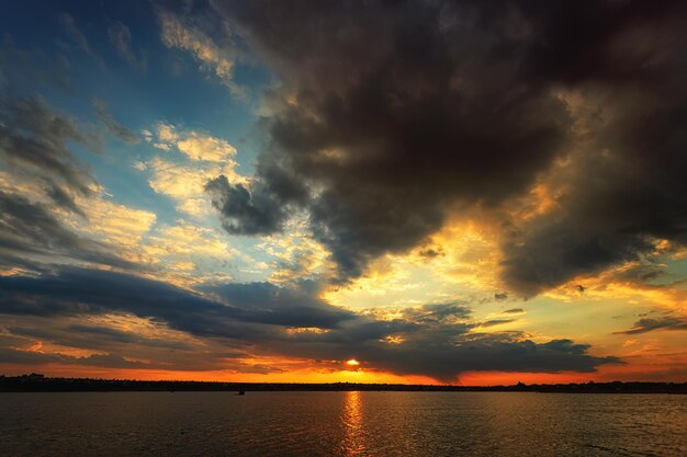 Tranquillo tramonto sull'acqua con splendide formazioni nuvolose