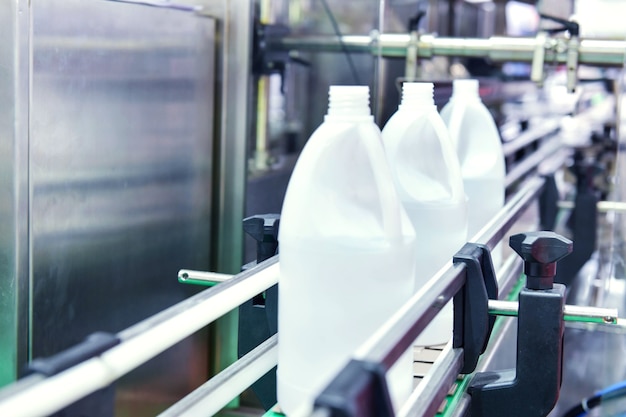 Trasferimento bottiglie in plastica bianca su sistemi di trasporto automatizzati industriali