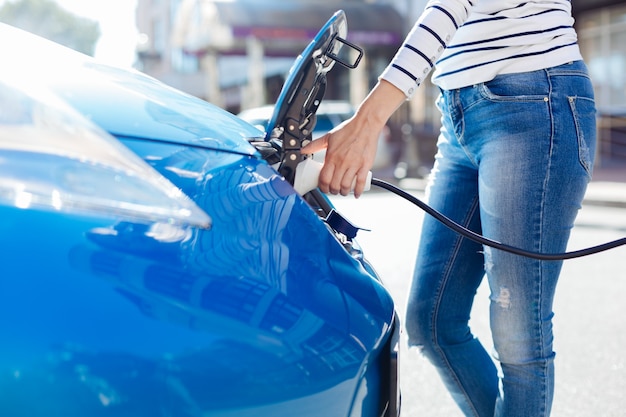 Trasporto ecologico. Primo piano di un caricabatterie elettrico professionale collegato alla macchina durante la ricarica con l'elettricità