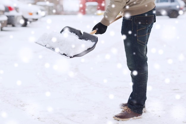 trasporto, inverno, persone e concetto di veicolo - primo piano dell'uomo che scava la neve con la pala vicino all'auto